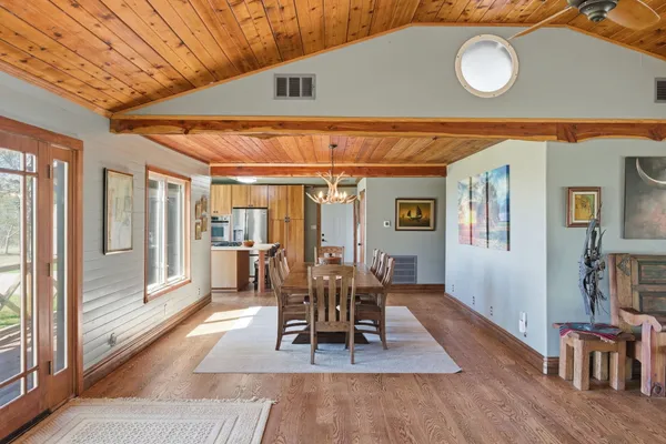 a dining room with wooden floor and large window