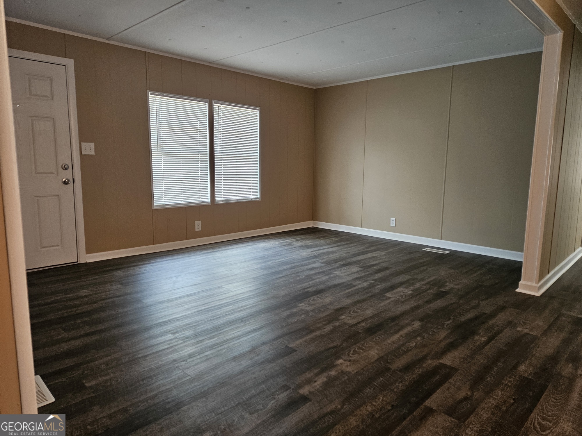 647 Buck Creek Road Sylvania, GA 30467 - Photo 12 of 16 an empty room with wooden floor and windows