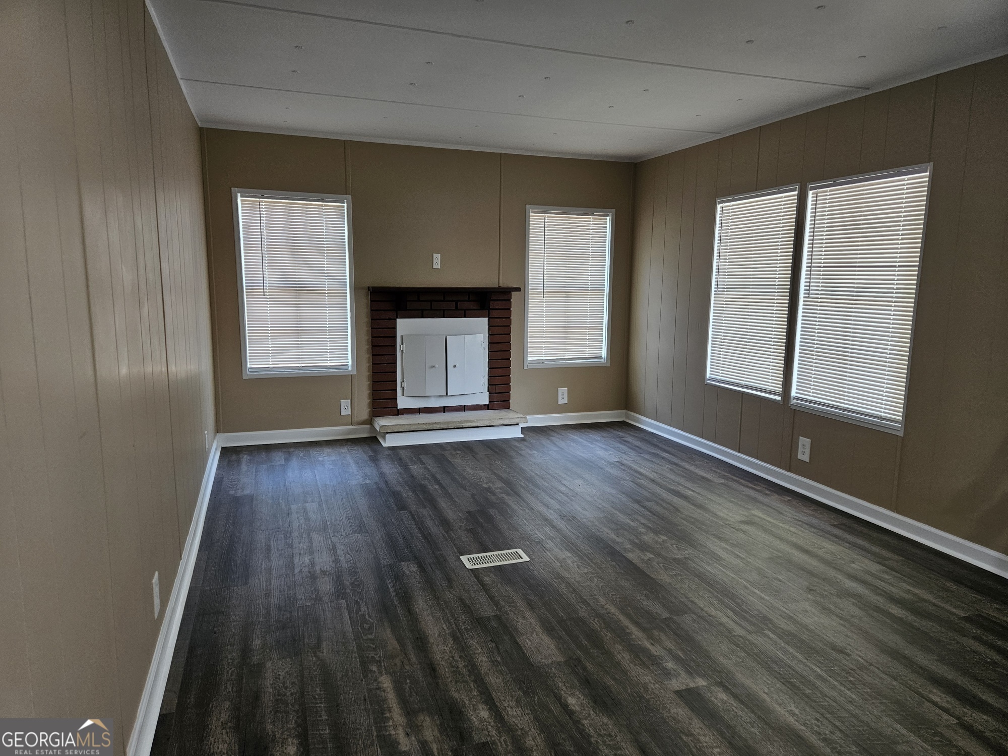 647 Buck Creek Road Sylvania, GA 30467 - Photo 6 of 16 an empty room with wooden floor and windows