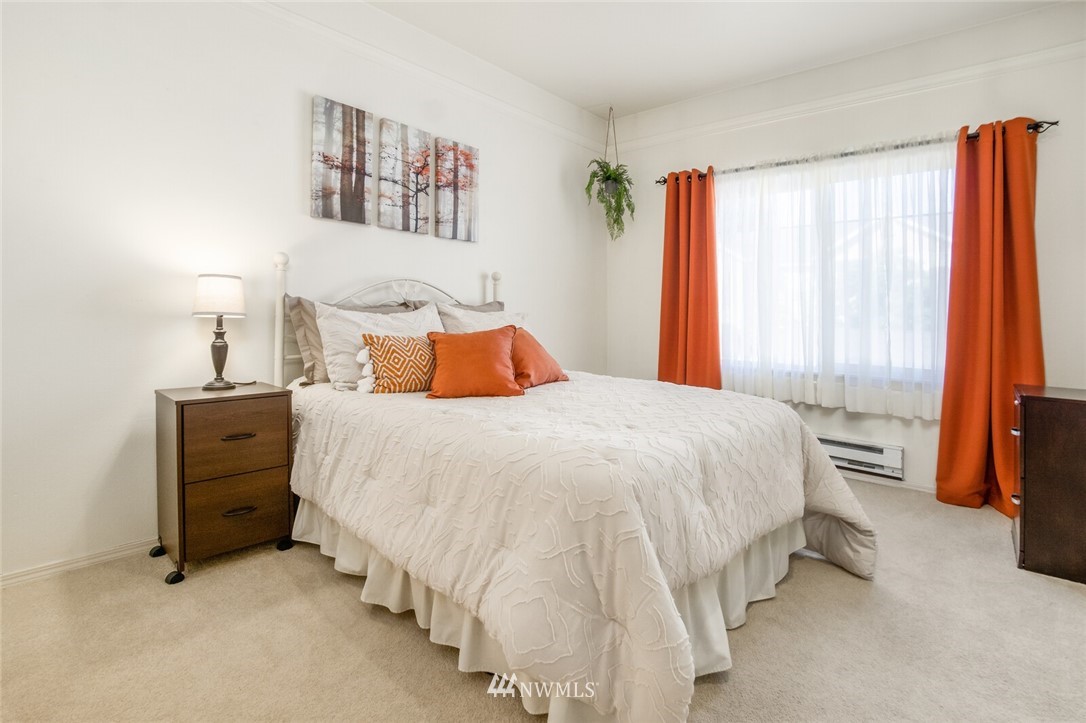 23908 Bothell Everett Highway, Unit A103 Bothell, WA 98021 - Photo 13 of 20 a bedroom with a bed and a large mirror