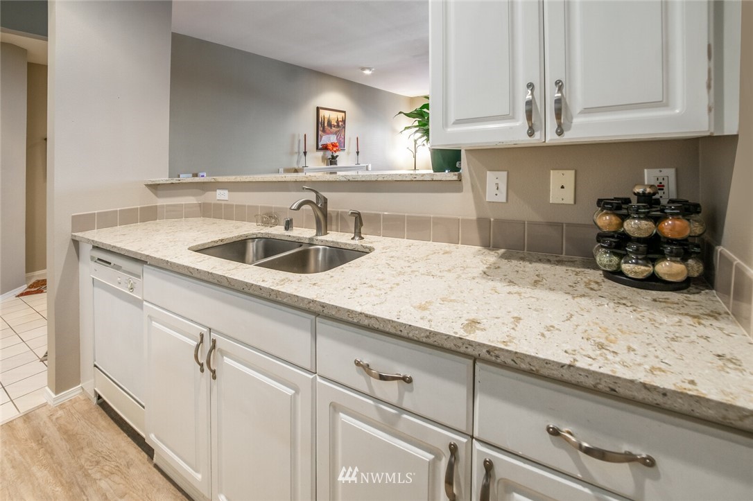 23908 Bothell Everett Highway, Unit A103 Bothell, WA 98021 - Photo 5 of 20 a kitchen with granite countertop white cabinets and a sink