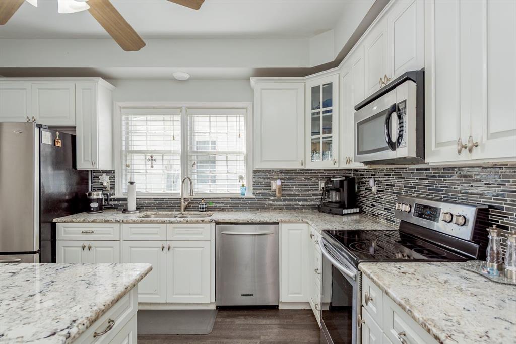 1111 West Line Street Leesburg, FL 34748 - Photo 14 of 77 a kitchen with stainless steel appliances granite countertop a stove sink microwave and cabinets