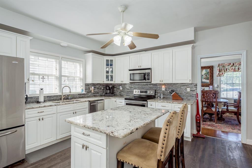 1111 West Line Street Leesburg, FL 34748 - Photo 15 of 77 a kitchen with kitchen island granite countertop a sink center island and stainless steel appliances