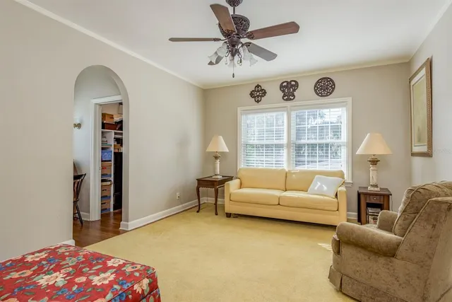 a living room with furniture ceiling fan and a wooden floor
