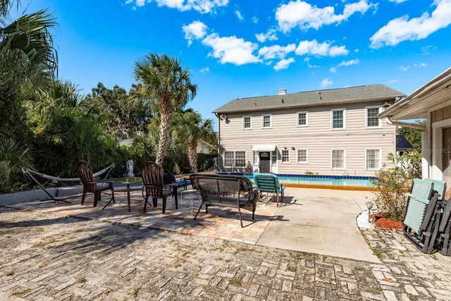 a view of a white house with a swimming pool and a yard