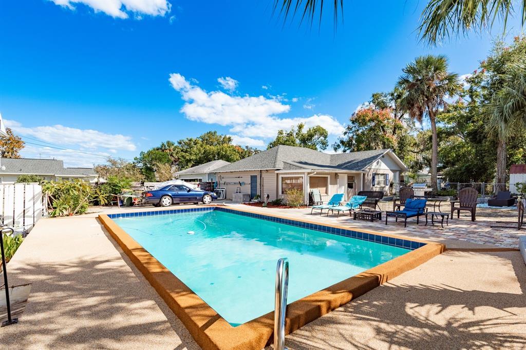 1111 West Line Street Leesburg, FL 34748 - Photo 48 of 77 a view of a swimming pool with lawn chairs under an umbrella