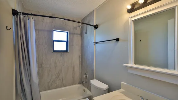 a bathroom with a granite countertop sink a mirror and a shower