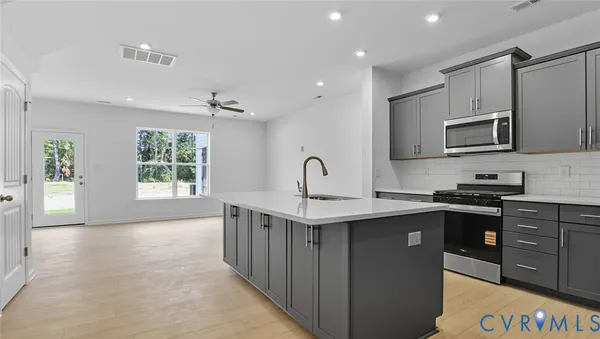 a kitchen with stainless steel appliances granite countertop a sink stove and microwave
