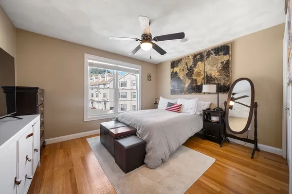 a bedroom with a bed and a flat tv screen on dresser