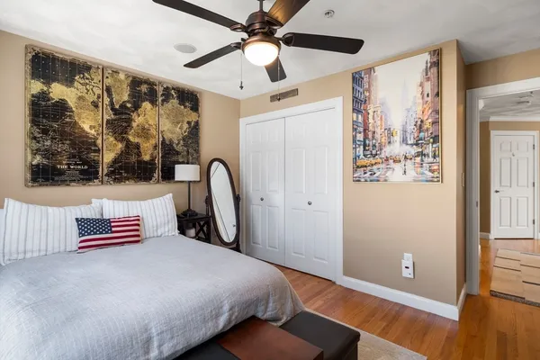 a bedroom with a bed and a painting on the wall