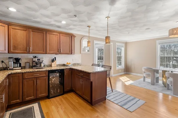 a kitchen with stainless steel appliances granite countertop a stove a sink dishwasher and a refrigerator with wooden cabinets