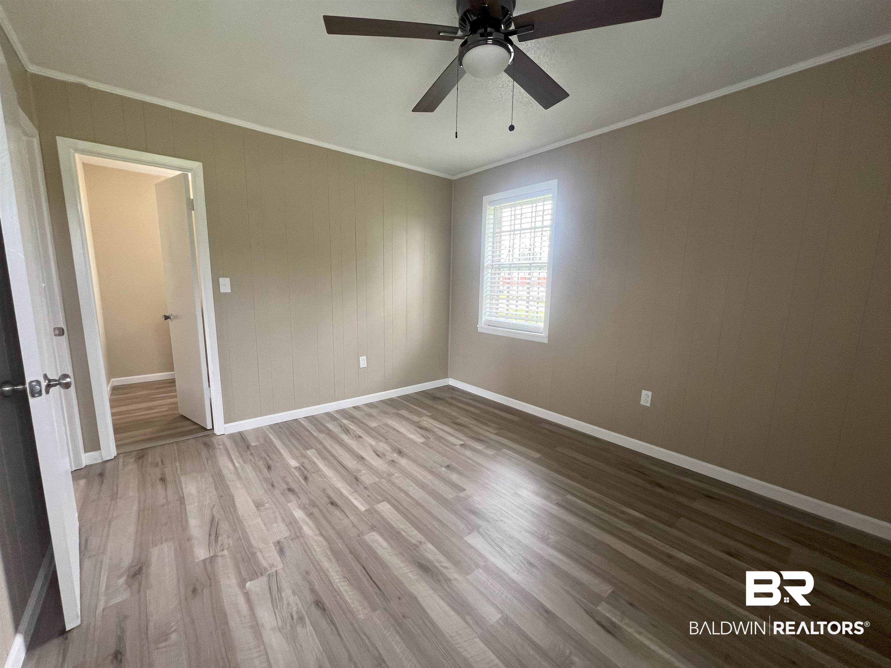 508 Freemanville Drive Atmore, AL 36502 - Photo 18 of 27 Unfurnished room with crown molding, ceiling fan, and wood-type flooring