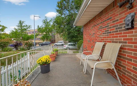 a balcony with chairs and potted plants