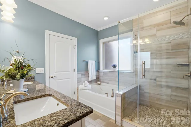 a bathroom with a granite countertop sink a mirror and shower