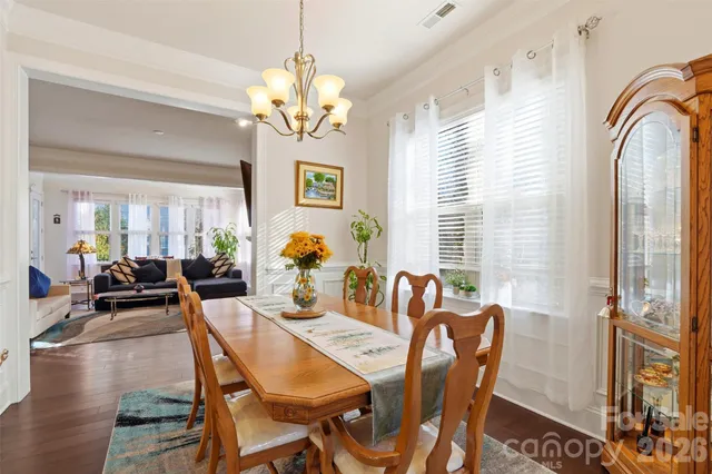 a view of a dining room with furniture a chandelier and wooden floor
