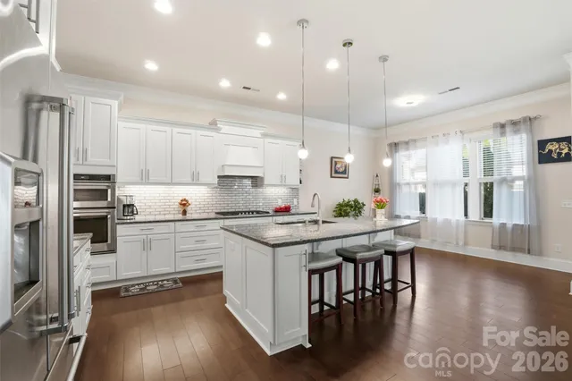a kitchen with a table chairs stove a refrigerator and cabinets