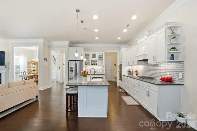 a kitchen with stainless steel appliances granite countertop a lot of counter space and wooden floor