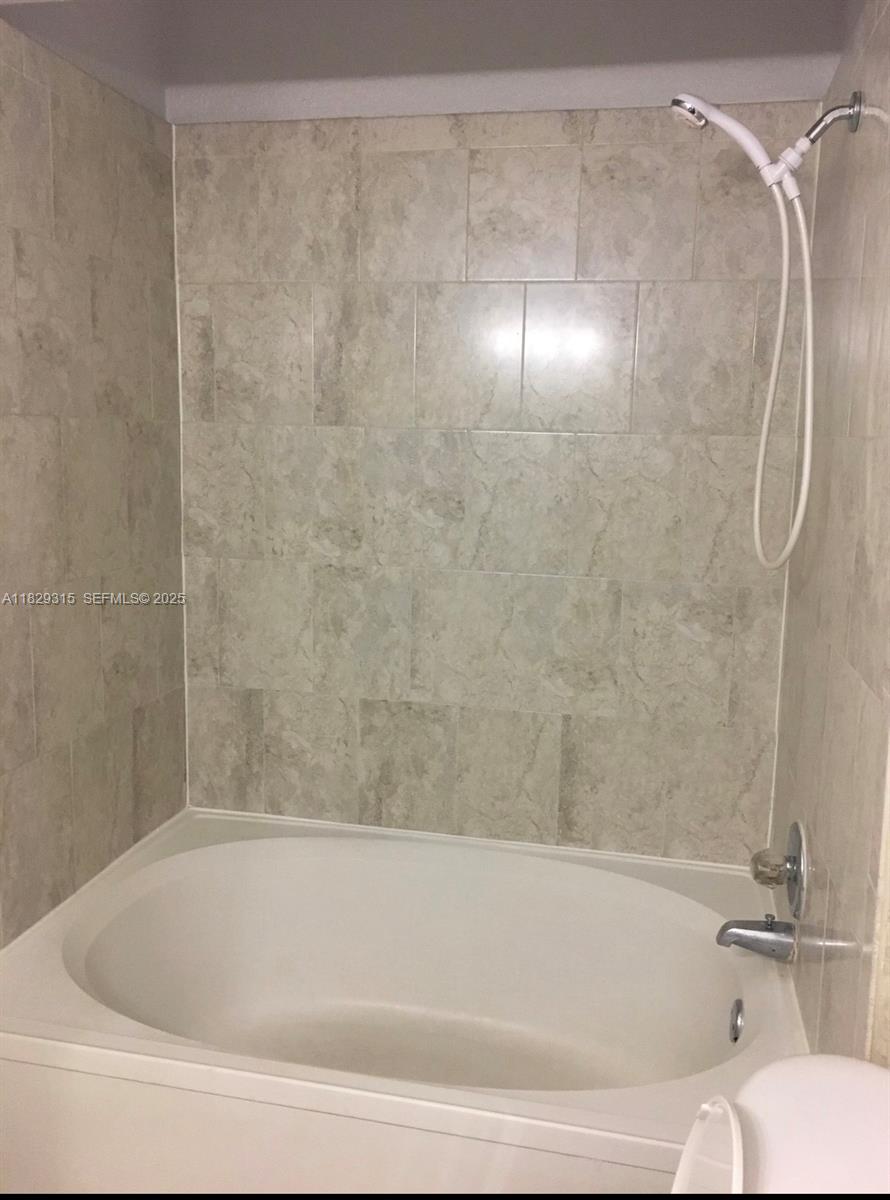 10670 Southwest 156th Place, Unit 309 Miami, FL 33196 - Photo 15 of 31 a bathroom with a shower and a bath tub