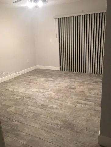 a view of a hallway with wooden floor and a living room