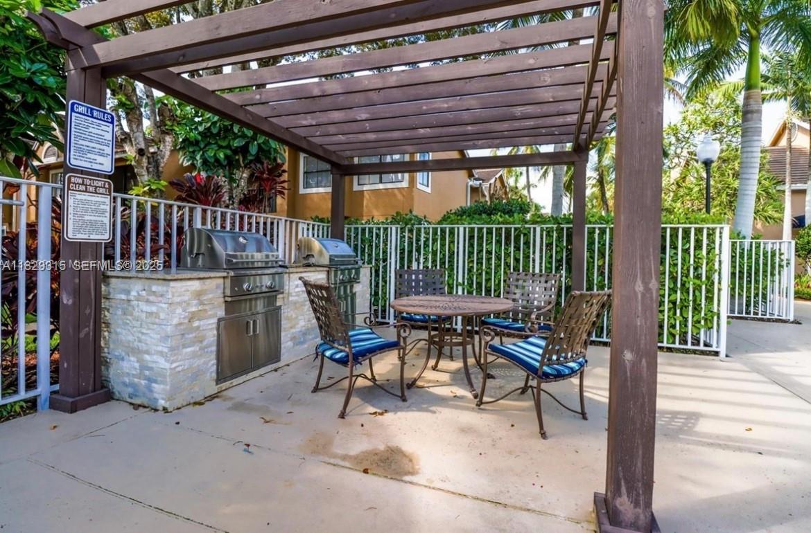 10670 Southwest 156th Place, Unit 309 Miami, FL 33196 - Photo 26 of 31 a view of a patio with a table and chairs