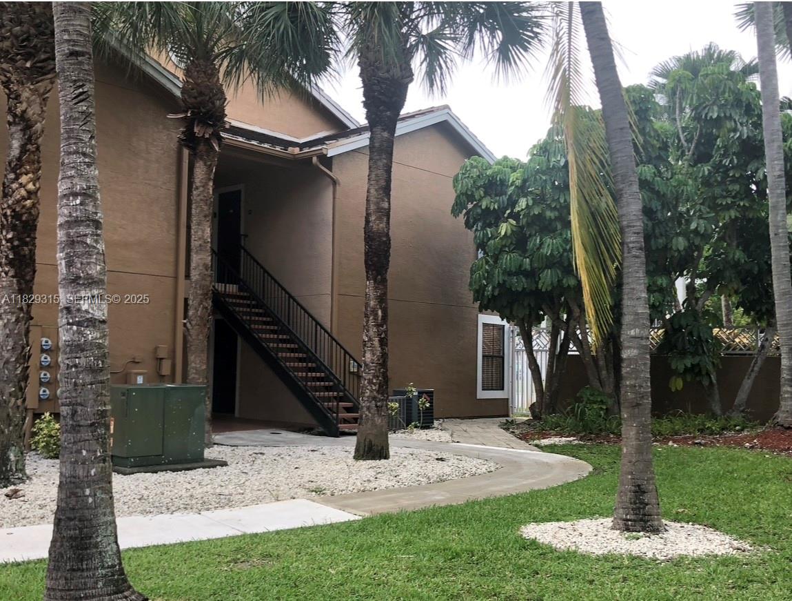 10670 Southwest 156th Place, Unit 309 Miami, FL 33196 - Photo 4 of 31 a view of a house with a yard and palm trees