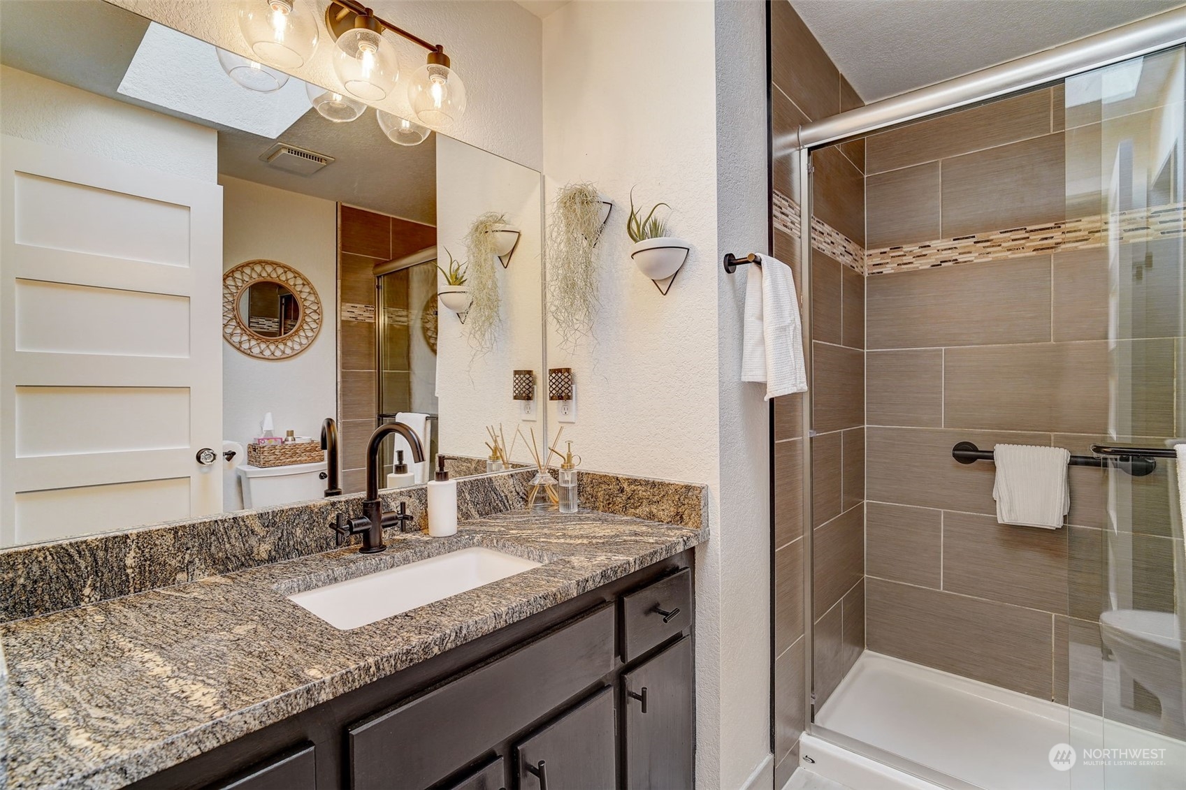 8825 Shell Place Edmonds, WA 98026 - Photo 22 of 40 a bathroom with a granite countertop sink a mirror and shower