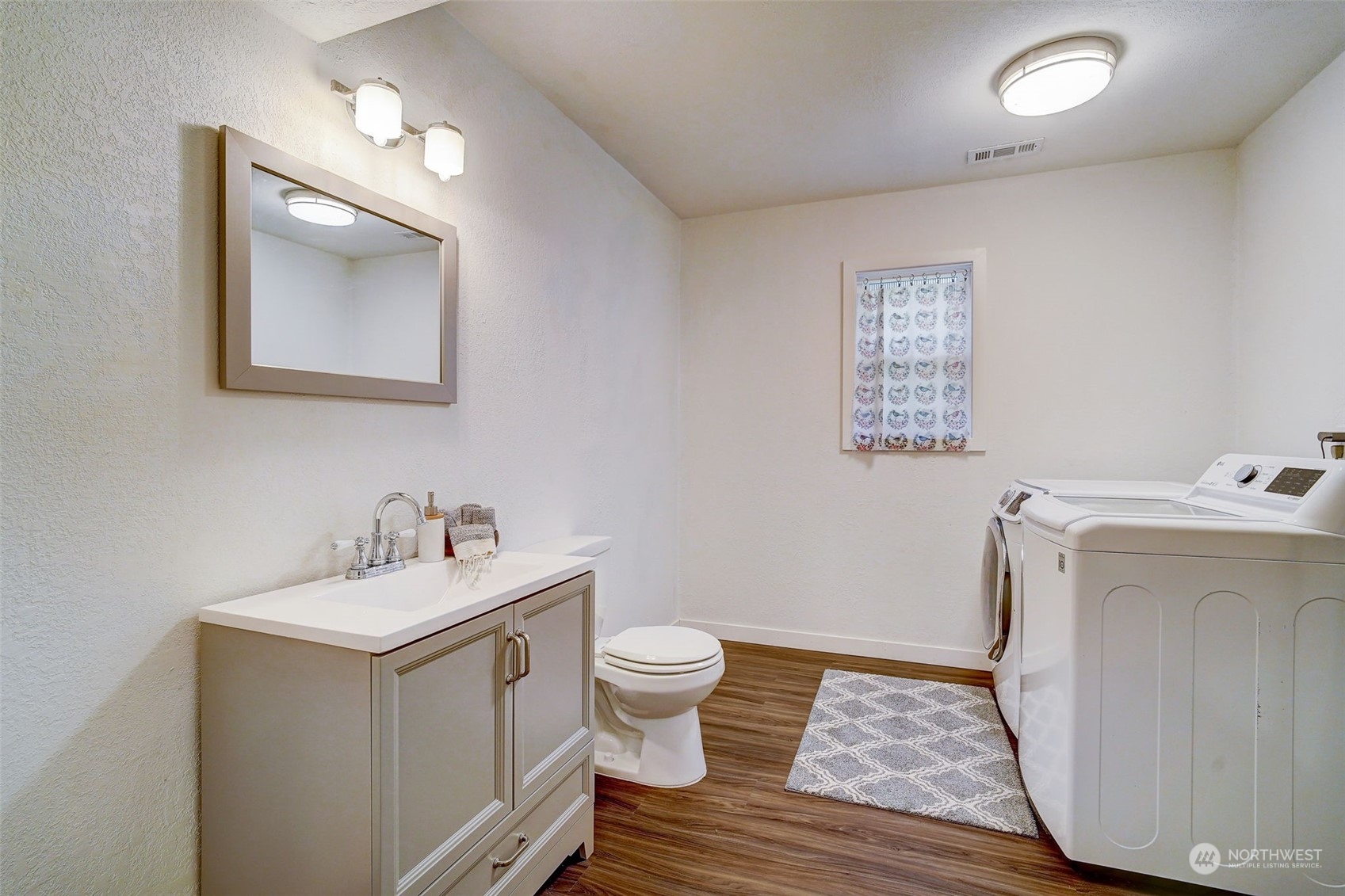 8825 Shell Place Edmonds, WA 98026 - Photo 25 of 40 a bathroom with a toilet sink and mirror