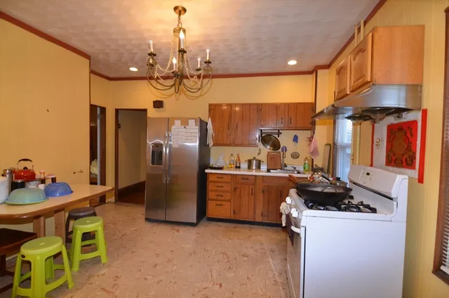 a kitchen with stainless steel appliances granite countertop a sink a stove and a refrigerator