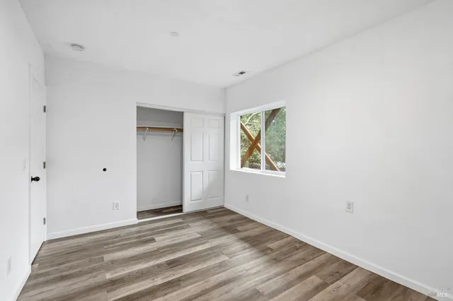a view of a livingroom with wooden floor and window