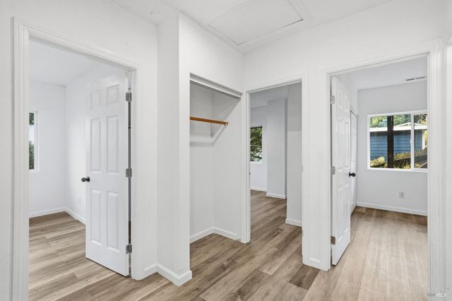 a view of a hallway with wooden floor and entryway