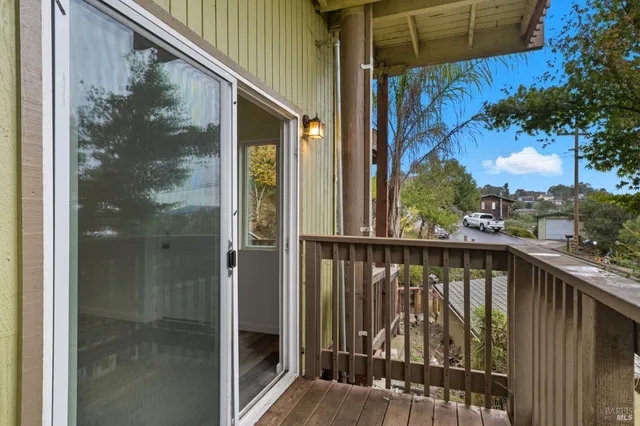 a view of a balcony with a floor to ceiling window and wooden fence