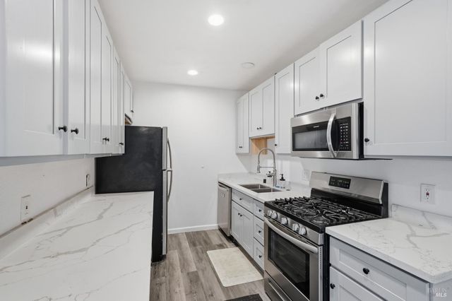 a kitchen with stainless steel appliances a stove microwave and sink