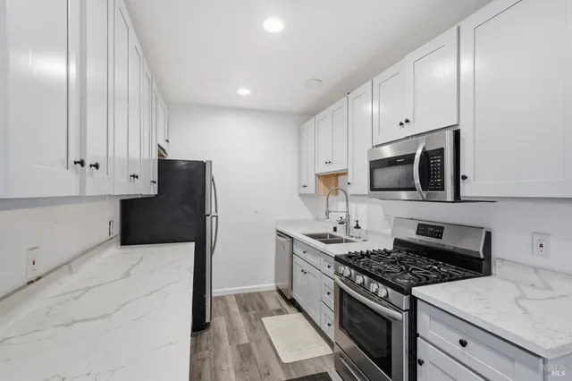 a kitchen with stainless steel appliances a stove microwave and sink