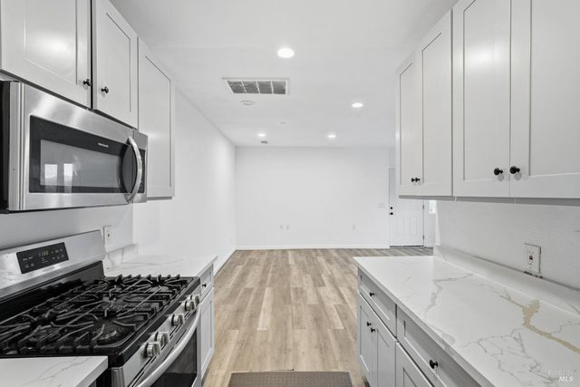 a kitchen with granite countertop a stove and a sink