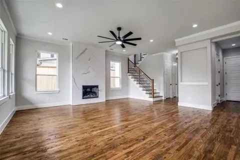 an empty room with wooden floor a ceiling fan and a window