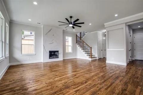 1702 Seevers Avenue Dallas, TX 75216 - Photo 11 of 24 an empty room with wooden floor a ceiling fan and a window
