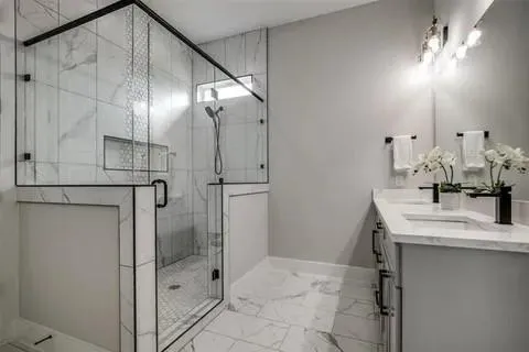 a bathroom with a granite countertop sink a mirror and shower