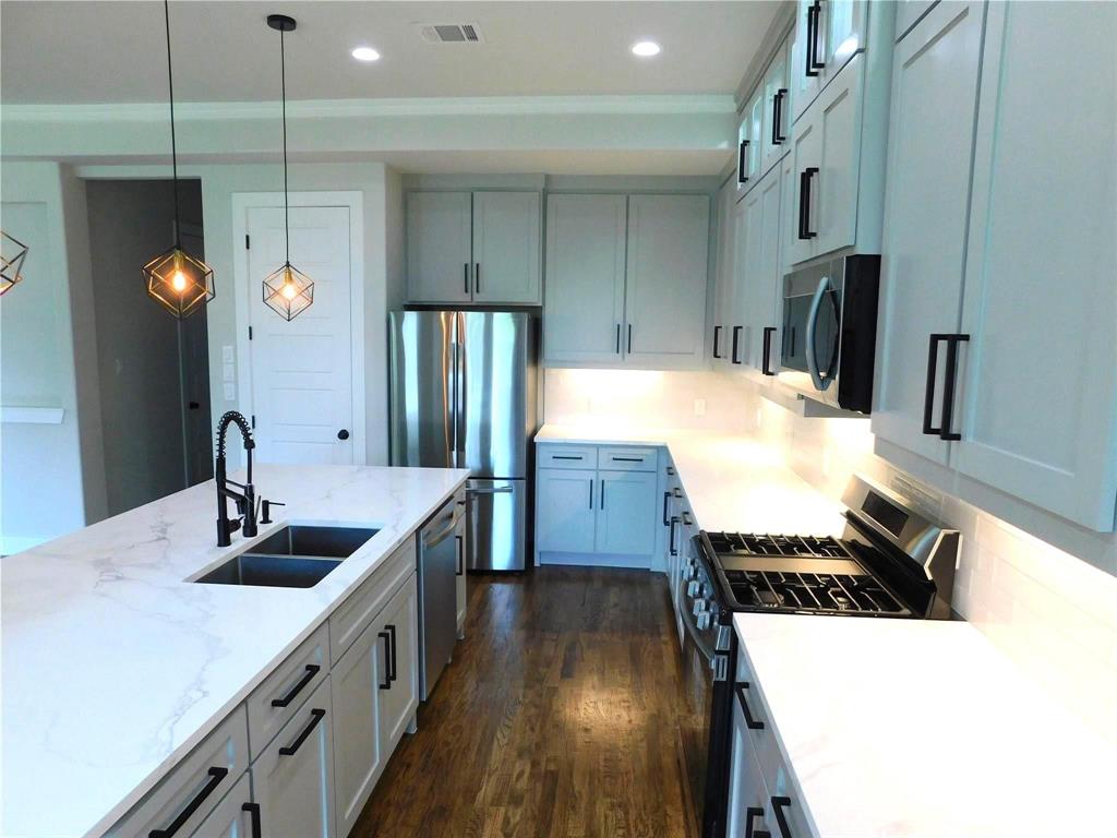 1702 Seevers Avenue Dallas, TX 75216 - Photo 6 of 24 a kitchen with stainless steel appliances a sink stove and refrigerator