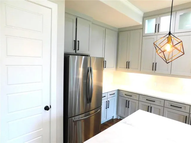 a kitchen with a refrigerator a sink dishwasher and cabinets
