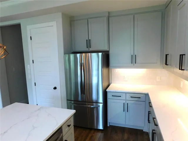 a kitchen with granite countertop a refrigerator and a sink
