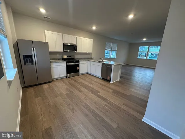 a kitchen with stainless steel appliances a refrigerator and a stove top oven