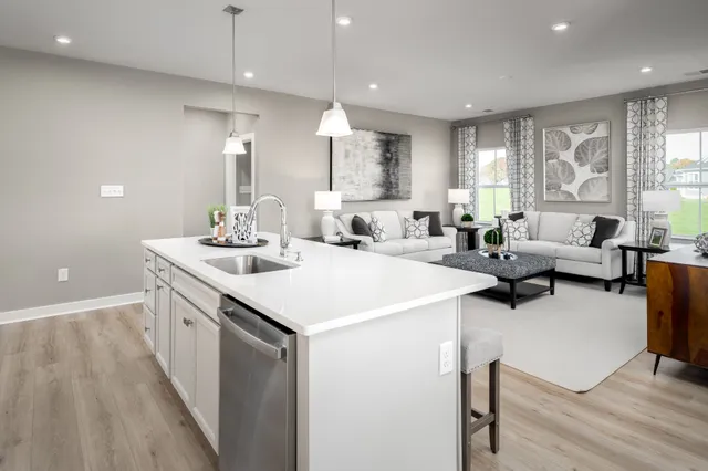 a kitchen with a sink a counter top space and living room area