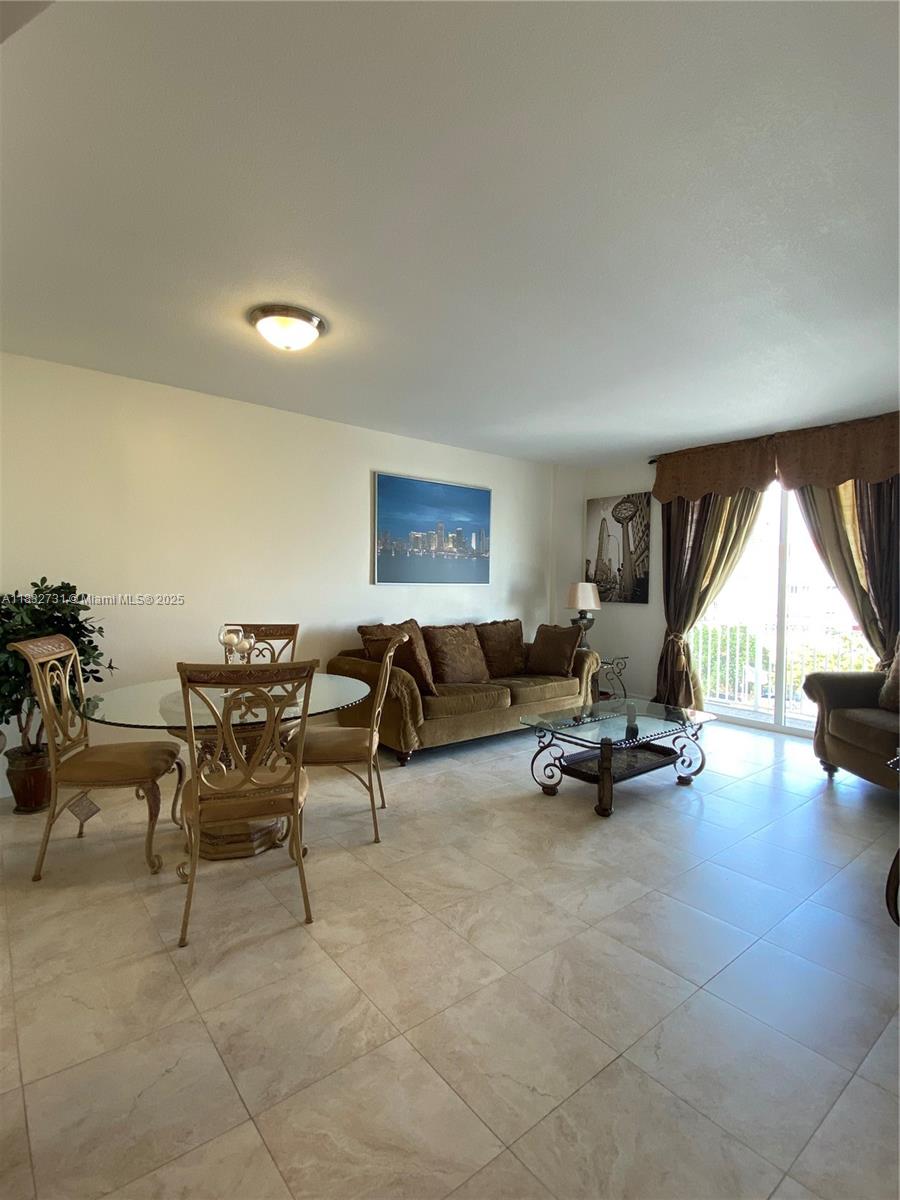 7270 Southwest 88th Street, Unit B502 Miami, FL 33156 - Photo 2 of 20 a living room with furniture and a large window