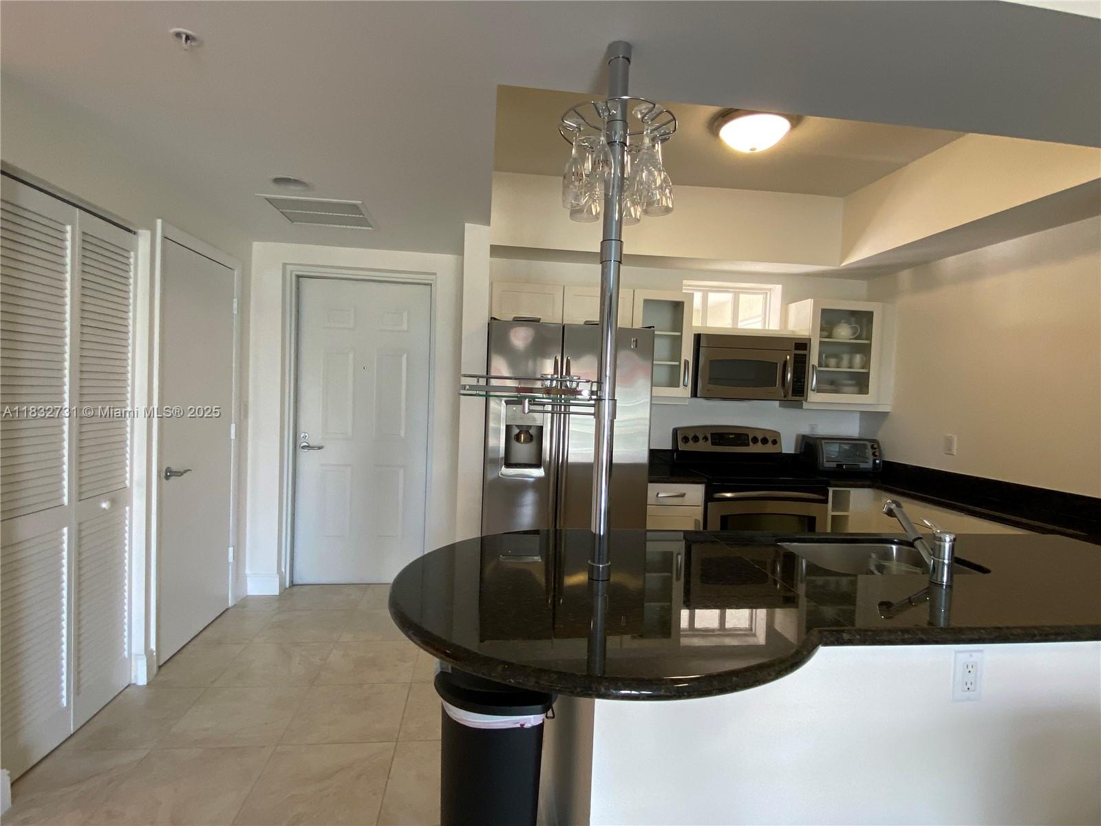 7270 Southwest 88th Street, Unit B502 Miami, FL 33156 - Photo 4 of 20 a kitchen with a appliances and chandelier