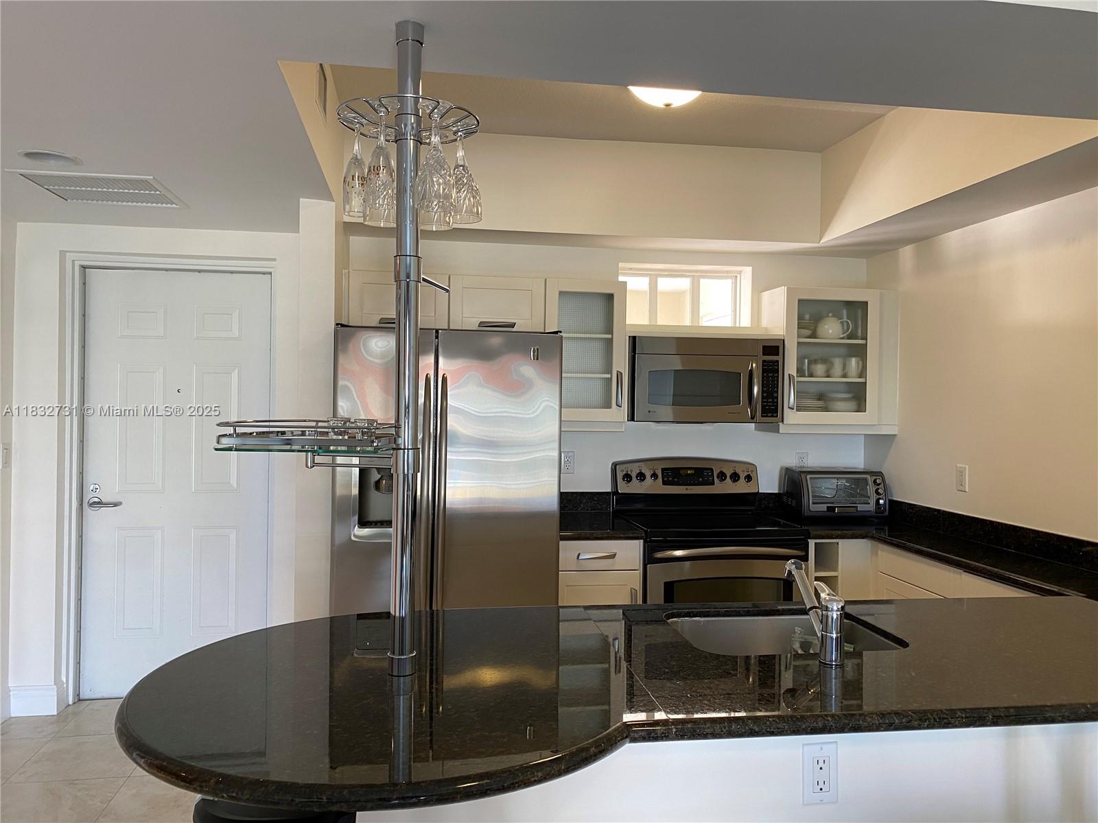 7270 Southwest 88th Street, Unit B502 Miami, FL 33156 - Photo 5 of 20 a kitchen with stainless steel appliances granite countertop a refrigerator a stove and a sink