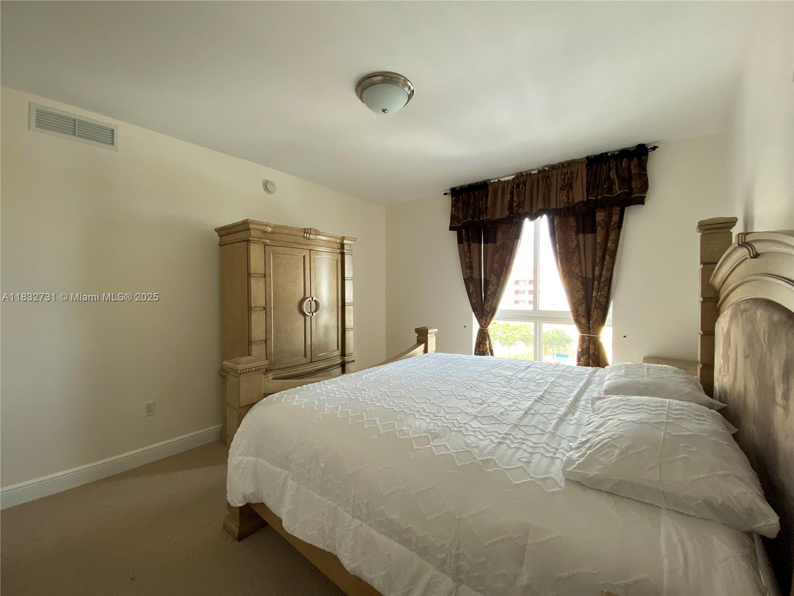 7270 Southwest 88th Street, Unit B502 Miami, FL 33156 - Photo 9 of 20 a bedroom with a bed and a window