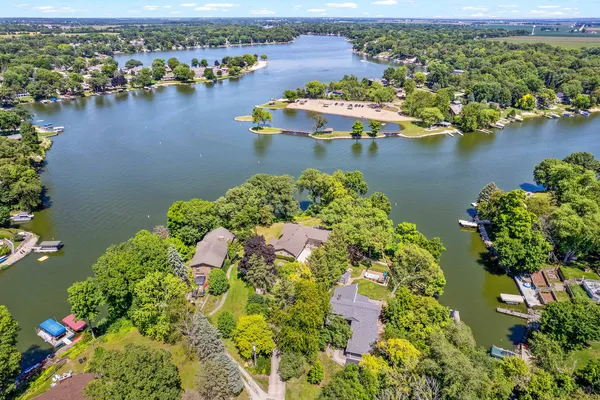 an aerial view of residential houses with outdoor space and lake view