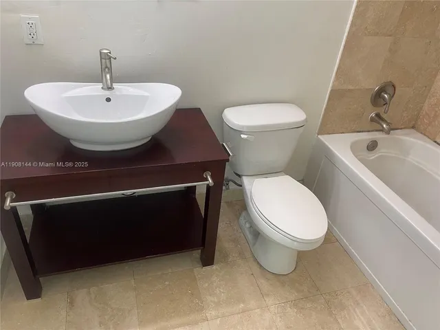 a white toilet sitting next to a bathroom sink