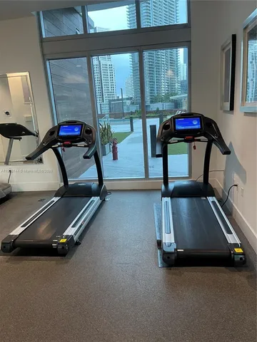 a room with gym equipment and floor to ceiling window