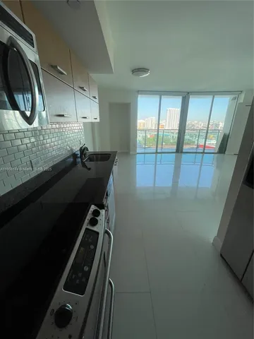a kitchen with granite countertop a stove and a shower